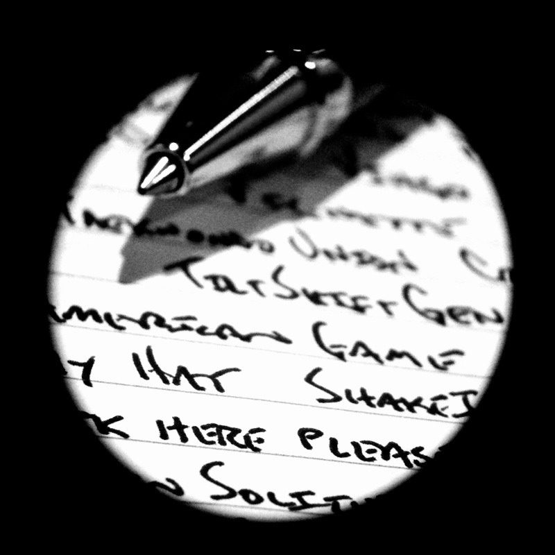 Nahaufnahme eines Stiftes auf bedrucktem Papier mit handschriftlichen Notizen